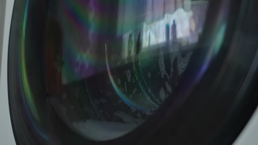 Washing machine working in the bathroom against the window