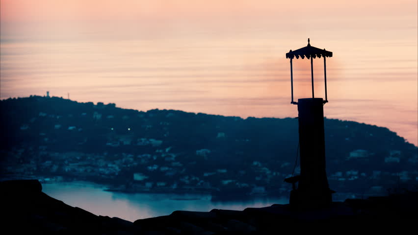 Aerial view a lighthouse with the Eze seaside commune in the Alpes-Maritimes at sunset on the background