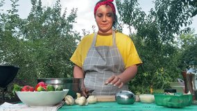 A young beautiful woman in an apron prepares food outdoors, cooking over an open fire in a grill. She enjoys the warm weather while skillfully handling ingredients in a relaxed outdoor setting. - Powered by Shutterstock - Get 15% off with code: PIKWIZARD15