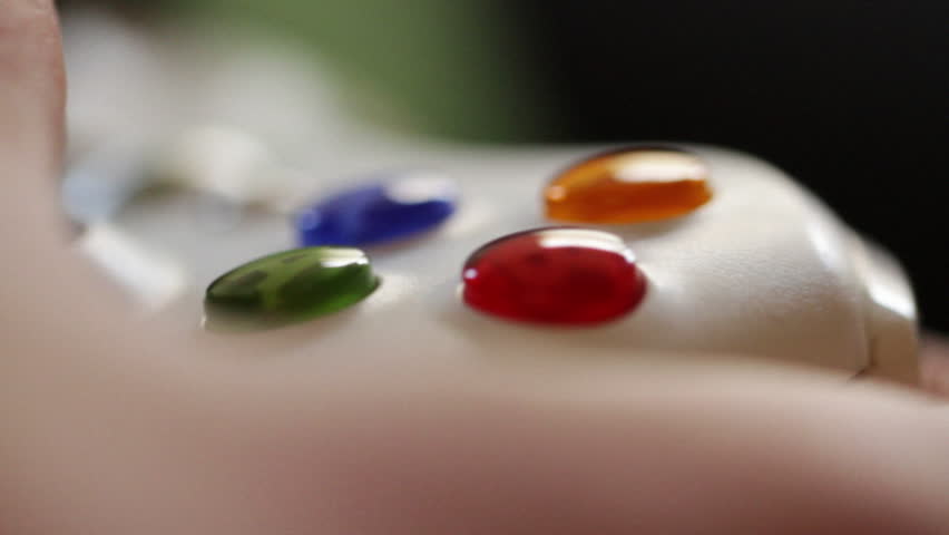 Teenage hands operate a video game controller, close detail view.