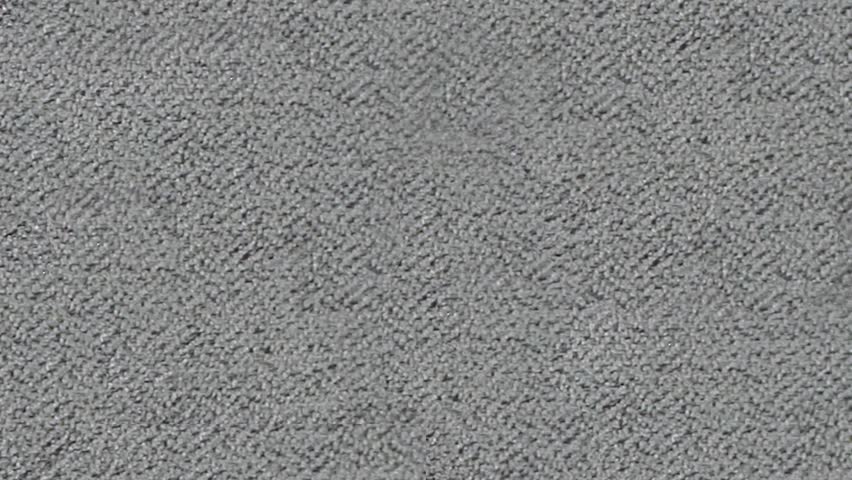 Macro view displays woven grey and dark grey fabric with refined pattern
