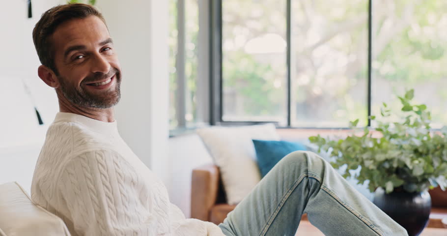 Face, relax or man with smile in living room for ambition, realtor career and development of housing business. Portrait, home or person with property consultant, real estate agent or mortgage listing