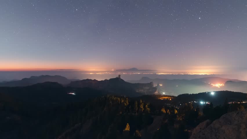 Breathtaking timelapse of Roque Nublo at night, nightlight scene over the mountains and Teide in the distance. A serene and cinematic scene, perfect for nature, travel, and adventure projects.