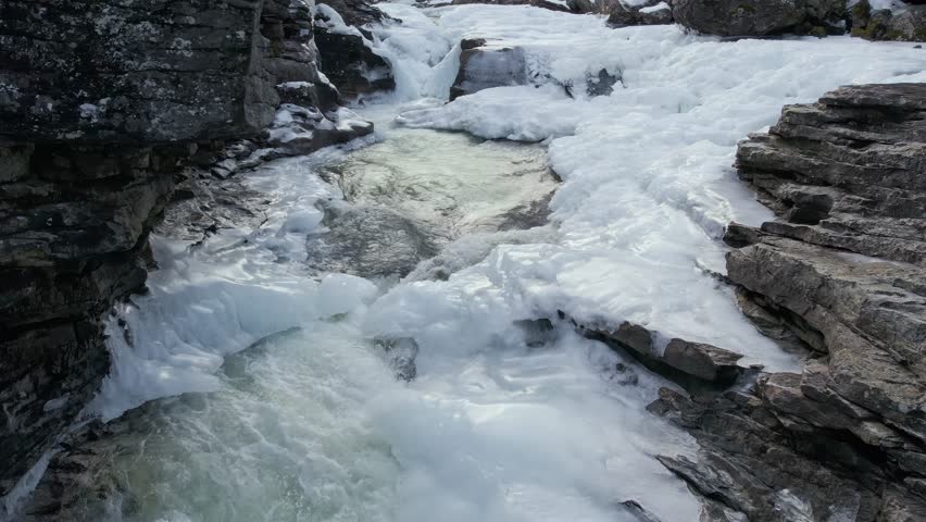 Frozen Waterfall on Rauma River Flowing Through Icy Rocky Landscape
