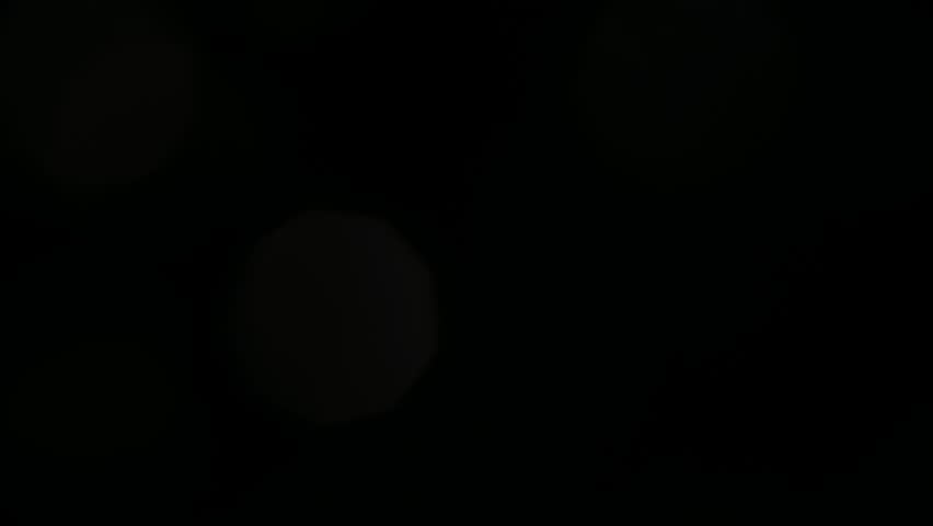 Shimmering glare on the lens of the camera, from the headlights of a passing car. Lens flare from the sun. Glare from a flashlight.