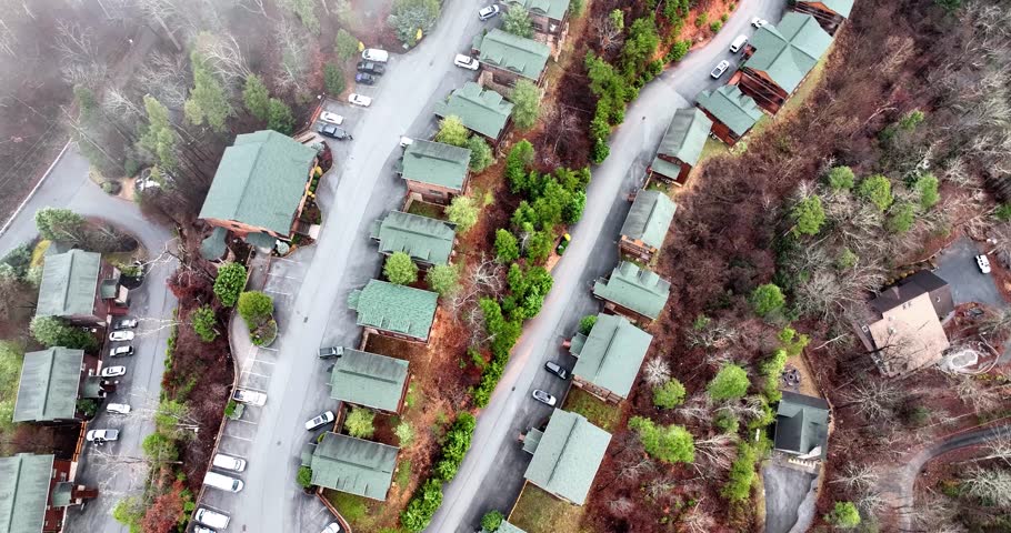 Aerial view of winter mountain cabins from above on a cloudy day