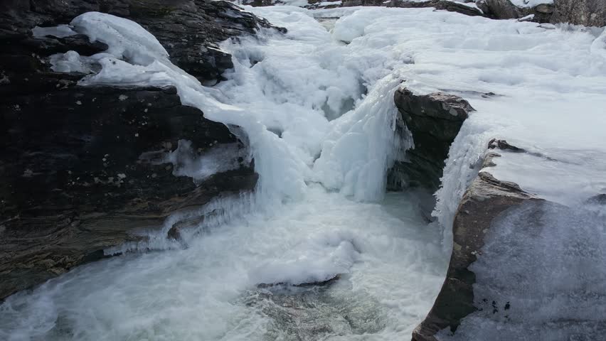 Icy Rapids of Rauma River Cascading Between Frozen Rocks