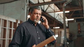 Carpentry, woodwork and mature man on a phone call in factory for furniture production, orders or contact. Construction, workshop and person on smartphone planning for timber, lumber or manufacturing - Powered by Shutterstock - Get 15% off with code: PIKWIZARD15