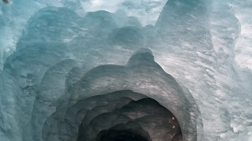 Walk through a glacier tunnel in the Alps