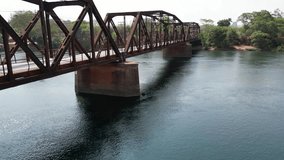 Aerial diagonal view of an old iron bridge spanning a pristine green-water river. The drone captures rusted beams, intricate metalwork, and the bridge’s reflection, blending industrial heritage. - Powered by Shutterstock - Get 15% off with code: PIKWIZARD15