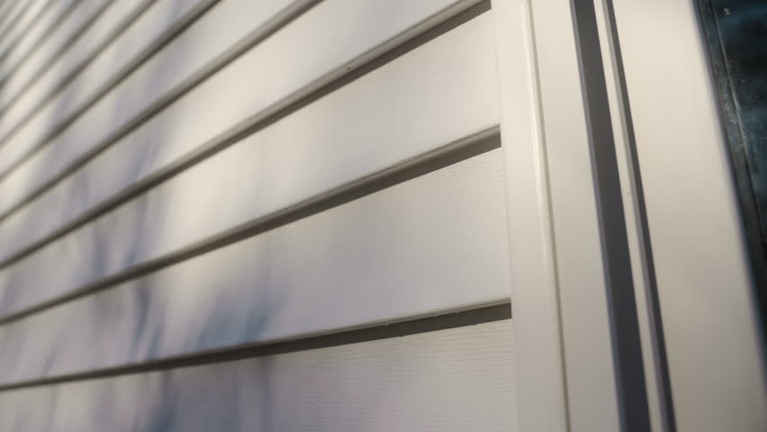 White siding house wall with clean, modern panels, providing a sleek and classic exterior look