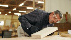 Carpentry, woodwork and man in workshop with dust on wood for furniture, manufacturing and lumber production. Construction, factory and carpenter blowing for planks, timber and board for renovation - Powered by Shutterstock - Get 15% off with code: PIKWIZARD15