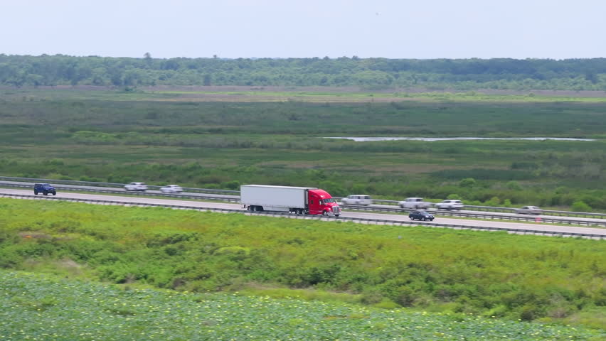 Semi truck driving on interstate freeway hauling cargo. Delivering loads concept.