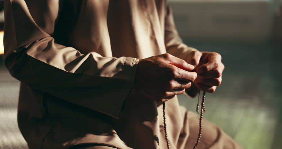 Home, praying and hands of Muslim man with beads for religious belief, worship and praise to Allah. Religion, spiritual and person with misbaha for prayer, salaah and fasting for Ramadan Kareem