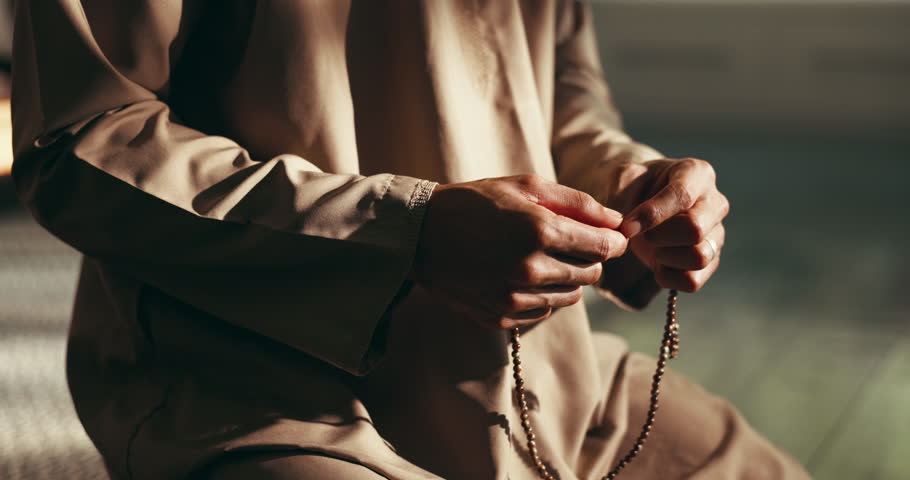 Home, praying and hands of Muslim man with beads for religious belief, worship and praise to Allah. Religion, spiritual and person with misbaha for prayer, salaah and fasting for Ramadan Kareem