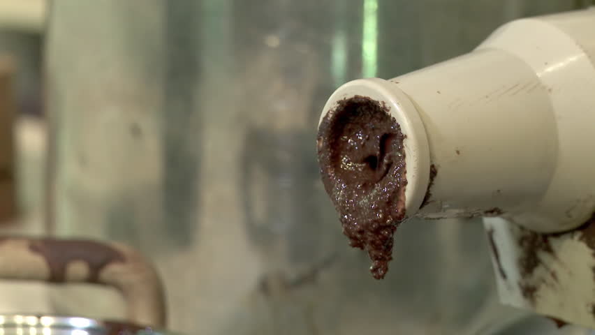 Chocolate nibs are fed through a juicer to make chocolate liquor.