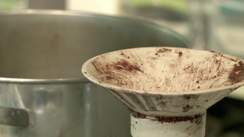 Chocolate nibs (roughly ground cocoa beans) are fed into a juicer to make