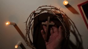 pov Hand holding wooden cross with crown of thorns and lit candles - Powered by Shutterstock - Get 15% off with code: PIKWIZARD15