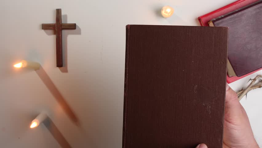 pov Open book bible, candles, cross and crown of thorns creating a spiritual atmosphere
