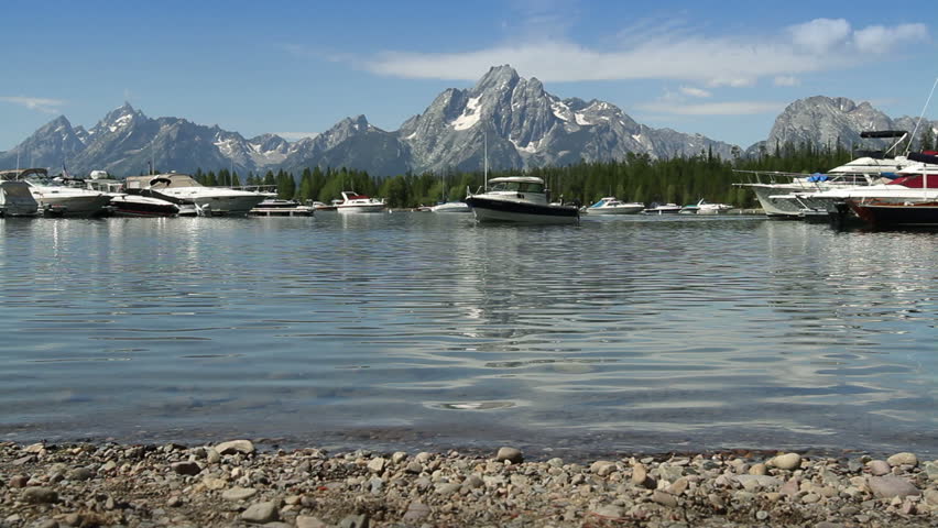 Boats bob about in front of a view of the Tetons looking across Jackson Lake in