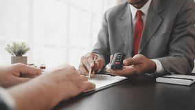 Car insurance documents or rental concept. A car broker helps his customers and explains the details of car contacts. Car keys. Buy or sell, sign.

 - Powered by Shutterstock - Get 15% off with code: PIKWIZARD15