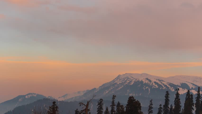4K Timelapse of Himalayan mountains during sunset in Gulmarg, Kashmir, India. Clouds moving over mountains during sunset. Timelapse of clouds and mountains, trees. Indian Himalayas