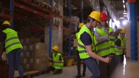 Warehouse workers wearing safety vests and helmets are scanning packages with barcode scanners and tablets, managing inventory and logistics in a busy distribution center - Powered by Shutterstock - Get 15% off with code: PIKWIZARD15