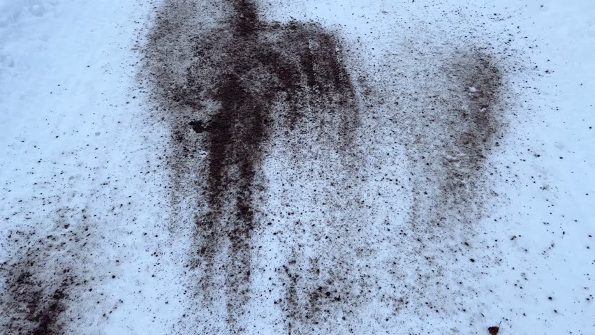 The road in a winter park or forest is sprinkled with sand and salt, reagents for roads. Winter, ice