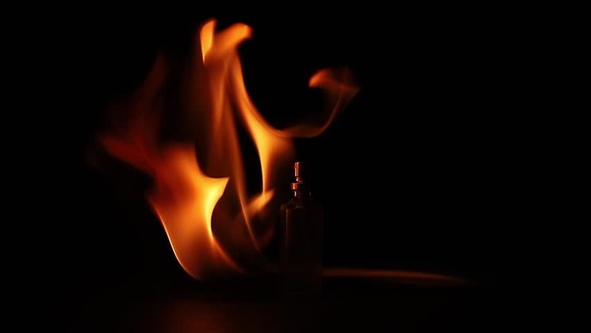 Perfume fire bottle. Mockup on the dark or black empty background. Perfume bottle in fire background. Glass of perfume on a dark background in flames.