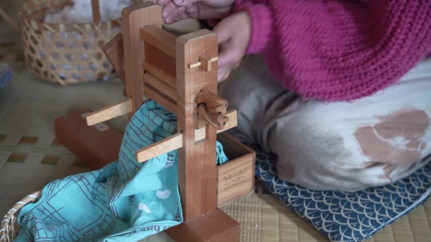 A woman using a cotton gin
