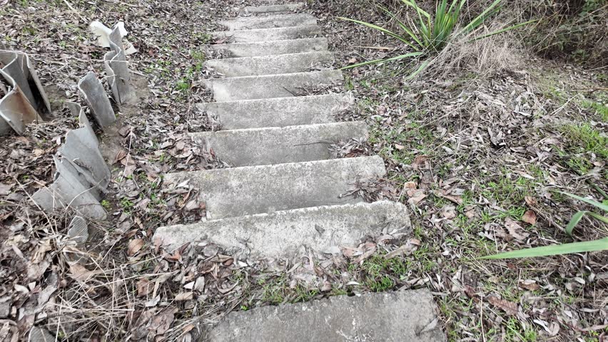 Point of view of a man's feet stepping down a natural wood staircase in a house. First person perspective on home tour concept. old dangerous staircase