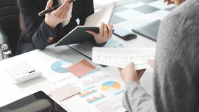 Two female business professionals in suits sit at desk, engaged in strategic discussion. They analyze financial planning, risk management, corporate growth while reviewing reports and market trends. - Powered by Shutterstock - Get 15% off with code: PIKWIZARD15