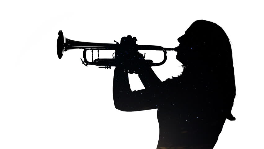 Young woman plays the trumpet in a studio with a timelapse of the night sky,