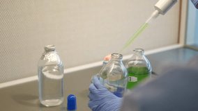 Close up footage of scientist using pipette to drop liquid into bottle on a chemical research laboratory. - Powered by Shutterstock - Get 15% off with code: PIKWIZARD15