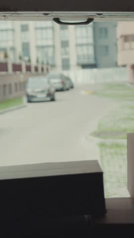 Portrait courier African American gives a parce to a woman after signing on delivery device cardboard technology box order post postal service device sunny beard covered load logistic mailman