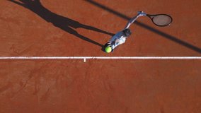 Aerial flat lay shot of a teenage male tennis player serving on a clay court. - Powered by Shutterstock - Get 15% off with code: PIKWIZARD15