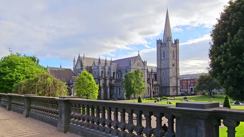 St Patricks Cathedral in Dublin, Ireland. Slow walking motion from terrace overlooking the grounds and iconic landmark near dusk.