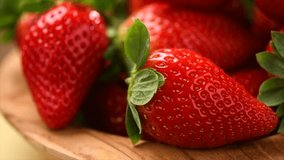 Strawberries, fresh ripe organic strawberry in a wooden bowl, close-up. Fresh ripe organic strawberries, macro shot of fresh juicy berries, close up, rotating  - Powered by Shutterstock - Get 15% off with code: PIKWIZARD15