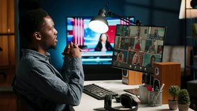 African American man and associates attending a virtual meeting call in his loft, discussing and communicating through a video conference, doing remote work at home. Camera B. - Powered by Shutterstock - Get 15% off with code: PIKWIZARD15