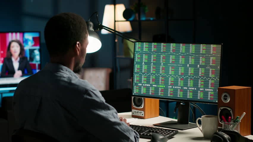 Male investor following stock exchange live trends on home computer, risking funds to increase company profit. African american guy looking at market trade values, planning development. Camera A.