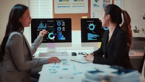 Collaborative financial analysis by Asian professional businesswomen reviewing data charts, graphs on computer screen in modern, bright office workspace - Powered by Shutterstock - Get 15% off with code: PIKWIZARD15