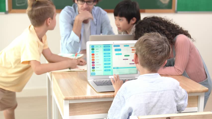 Smart caucasian boy turn around and looking at camera in STEM technology class while group of diverse student and teacher doing mind mapping. Smart child learning coding software program. Pedagogy. - Powered by Shutterstock - Get 15% off with code: PIKWIZARD15