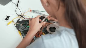 Top view of girl learning or studying mother board construction with electronic equipment. high school student inspect or fixing electronic board with laptop placed on table. Creative. Edification - Powered by Shutterstock - Get 15% off with code: PIKWIZARD15