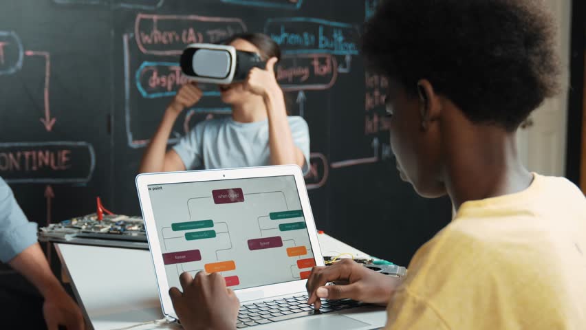 African boy programming system while caucasian girl enter metaverse while sitting at blackboard with engineering code written.high school girl wearing VR or headset in STEM technology. Edification