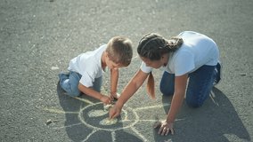 Children drawing chalk on asphalt. Children creatively sketch sun outdoors. Siblings enjoy drawing together asphalt. Fun childhood activity children draw chalk. Kids creativity drawing chalk asphalt. - Powered by Shutterstock - Get 15% off with code: PIKWIZARD15