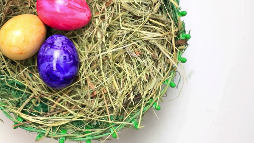 A beautifully shot Easter nest filled with vibrantly colored eggs, symbolizing new beginnings and festive traditions. Great for Easter promotions and seasonal themes.