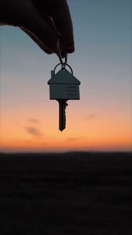 in hand, the key to the house against a beautiful sunset. Silhouette. Concept of construction and real estate transactions. Family relation.