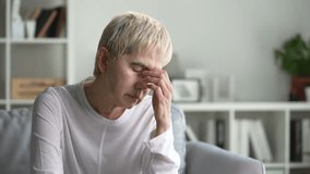 Senior woman sitting on sofa suffering from headache - Powered by Shutterstock - Get 15% off with code: PIKWIZARD15