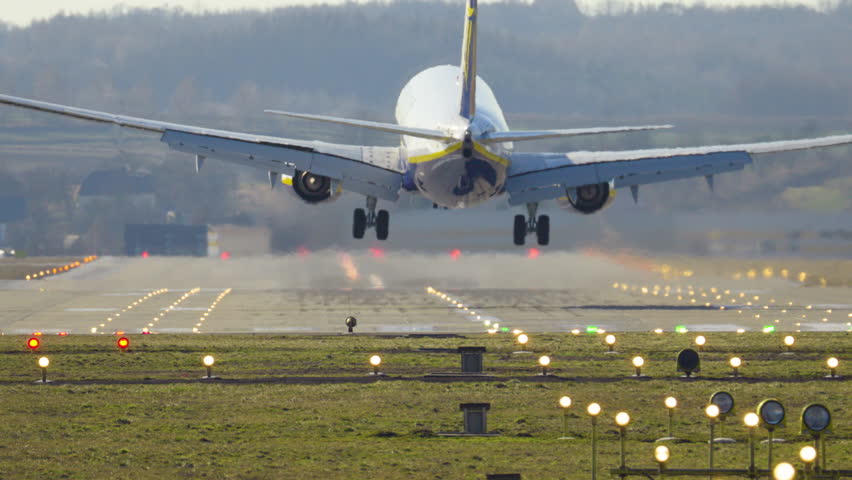 Passenger plane performs controlled landing on runway enhancing travel experience in busy airport setting