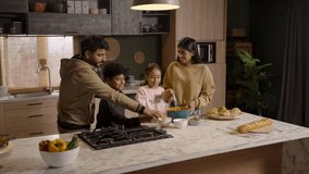 A joyful family—father, mother, son, and daughter—laugh together in the kitchen as they bake, playfully sprinkling flour on each other in a fun, messy moment.
 - Powered by Shutterstock - Get 15% off with code: PIKWIZARD15